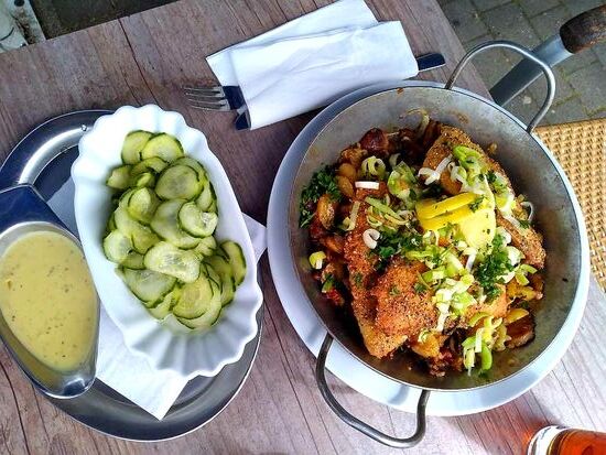 Gebratene Fischfilets auf Gemüse mit Bratkartoffeln und Gurkensalat