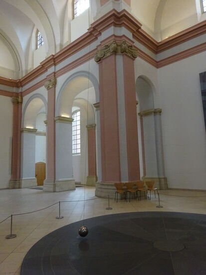 ..........das dauerhaft installierte Kunstwerk von Gerhard Richter, das "Foucaultsche Pendel". Eine 48kg schwere Messingkugel pendelt an einem 20m langen Drahtseil. Im Boden befindet sich ein magnetisches Feld als Antrieb. Mit diesem  Versuch hatte 1851 der Physiker Léon Foucault die Erdrotation ohne Himmelsbeobachtungen sichtbar gemacht. Gerhard Richter hat dieses Kunstwerk erschaffen und der Stadt Münster geschenkt. Die Übergabe erfolgte 2018.