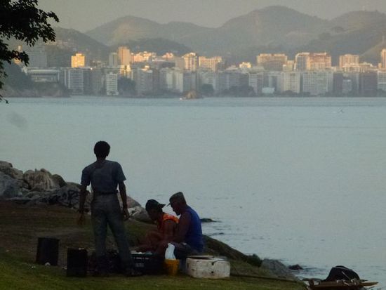 stadt der kontraste, waehrend sich ein paar menschen von funden aus dem abfall eine mahlzeit kochen, gehen in den luxusapartments an der copacabana die lichter an.