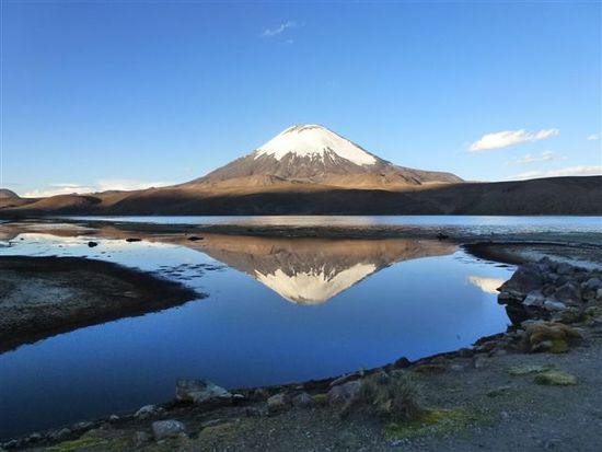 v parinacota spiegelt sich zum sonnenuntergang im lago chungara.