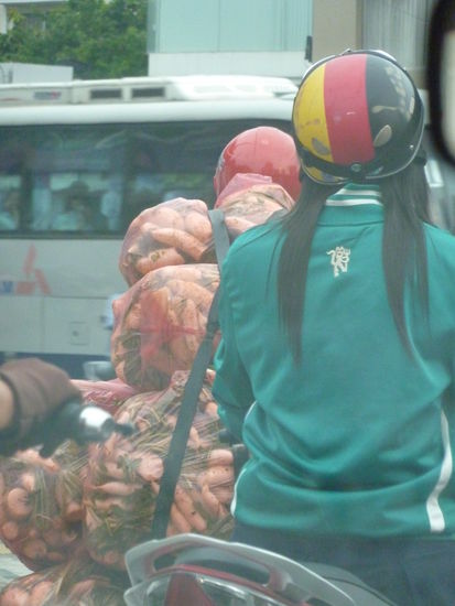 hehe, die hat sich schon auf die WM vorbereitet! Und vor ihr fährt der Rettichlieferant! Den hab ich leider nicht mehr als Vollbild gekriegt! Der Roller war rundum mit Tüten behängt! 