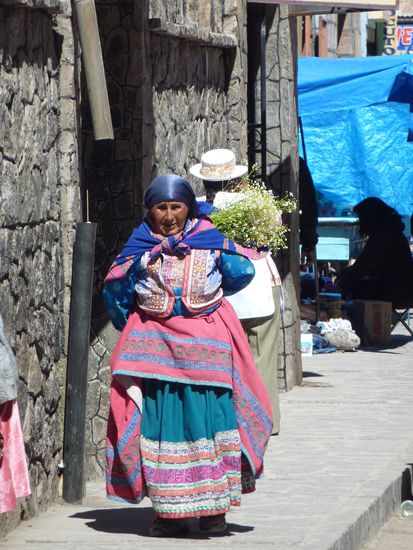 Die Frau hier traegt jetzt Tee mit sich herum, sie haben aber auch gerne Alpacafutter in ihren Tuechern auf dem Ruecken 