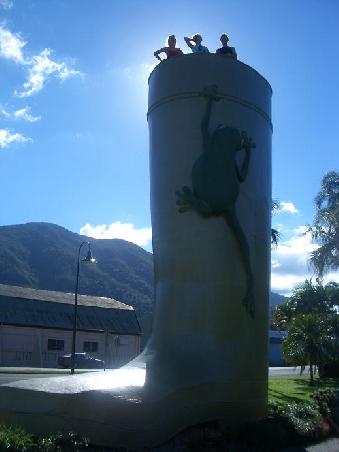 "Welcome to Tully -
wettest place of Australia!"
Und wir haben es doch glatt geschaft ein Foto vom Wahrzeichen - dem riesen Gummistiefel - bei strahlendem Sonnenschein zu machen! Ich steh uebrigens in der Mitte... Und das was da an der Seite hochkrabbelt ist wohl das 2. Wahrzeichen: Ein Frosch.