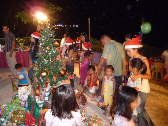 Alle Kinder laufen singend um den Christbaum herum. Jedes von ihnen hat für ein bestimmtes anderes Kind ein Geschenk. Nacheinander werden die bunt verpackten Geschenke überreicht.