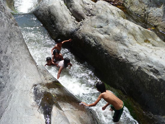 Die Kinder benutzen die ausgeschliffenen Felsen als Wasserrutsche, alle haben mächtig viel Spaß und kreischen und lachen