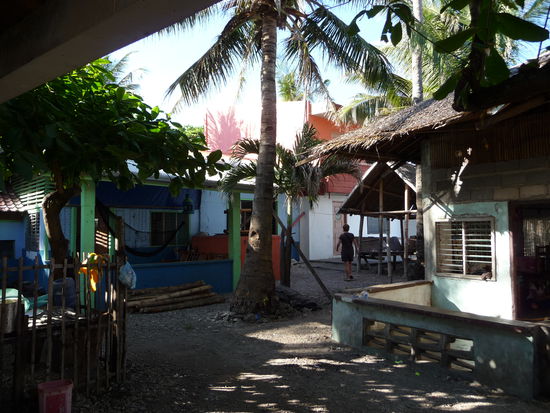 Noch einmal quer durch die Höfer der Nachbarschaft und schon sind wir da. Im Hintergrund sieht man bereits unser Häuschen, Andrea läuft schnurstracks darauf zu.