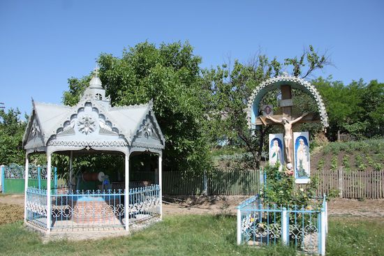 Überall gibt es schön verzierte Brunnenhäuschen mit einem ebenso verzierten Kreuz nebenan