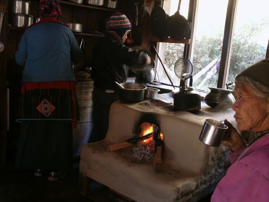Tag 6 Rueckweg nach Langtang. Feuerstelle (Kueche) im Aufenthaltsraum mit Oma und Enkel.