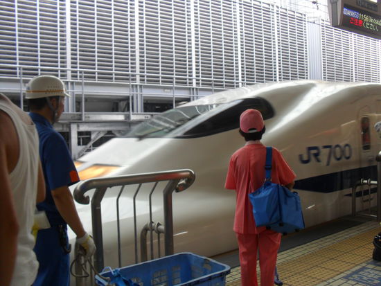 unser Shinkansen fährt ein. Die Dame in Rosa und der Herr in Blau gehören zum Putz-Team, was vorher noch alle Sitzpläze ein Mal dreht, damit niemand rückwärts fahren muss... und natürlich wird geputzt und so...