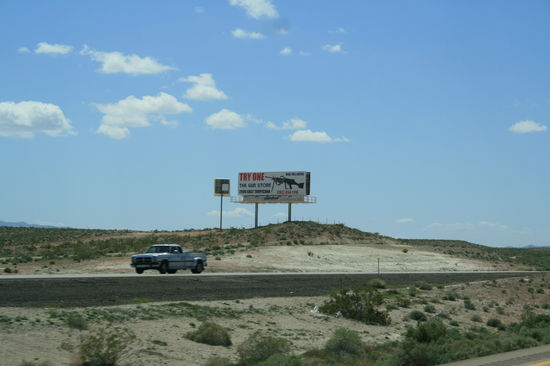 Werbeschild in der Wüste für eine vollautomatische Knarre.