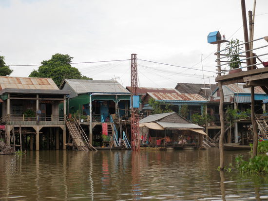 Es gibt drei Arten von Häusern: Solche auf Stelzen wie hier, solche auf Bambusflossen und die Ärmsten wohnen auf einfachen, gedeckten Booten. Die meisten Bewohner leben von der Fischerei. Täglich werden mehrere Lastwagenladungen in die Hauptstadt Phnom Penh geliefert. 