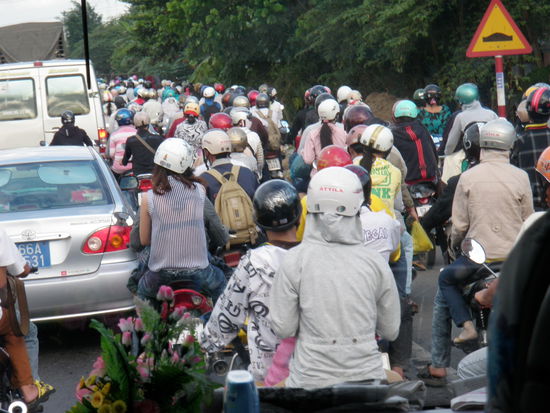 Auf der Strasse Richtung HCMC. Was fuer ein Chaos. Mopedfahrer eigentlich rechts, aber überall, und Autos links, die regelmässig nach rechts abbiegen. Aber es funktioniert.