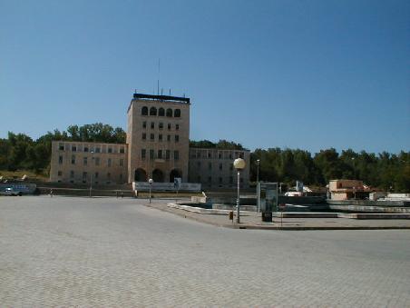Gegenüber des Wirtschaftsministeriums am Ende des grossen Boulevards von Tirana befindet sich das Hauptgebäude der Universität. Von hier aus sind es wenige Schritte und Sie befinden sich vor dem grossen Fussballstadion.
