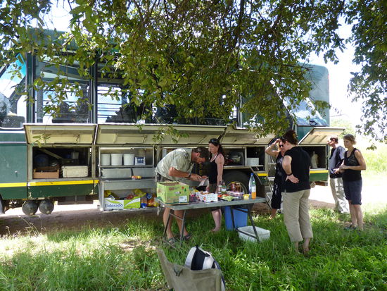 1.Klappe  Kocher und Zubehör 2 und 3. Klappe Teller Becher Besteck usw.Lebensmittel  4.Klappe Töpfe Spülkiste Wasserbehälter dann Treppe ,Klappe hinten  4Zelte.  Auf der Rückseite hintere Klappe 4 Zelte .  Dann Schlafmatten,dann Stühle  usw.