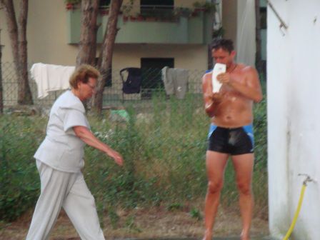Patric beim Duschen während die Frau Kartoffeln wäscht und das Geschirr macht