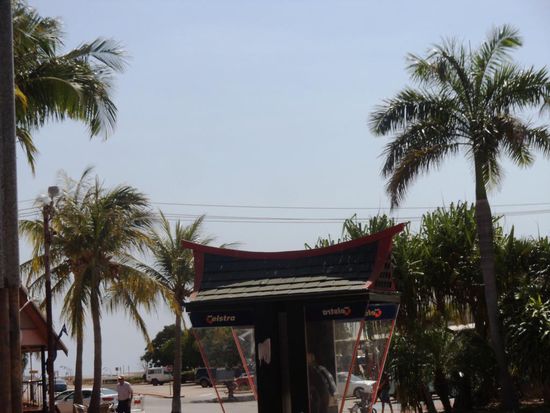 War wieder einmal zu spät. Genau über diese Telefonkabine und zwischen den beiden Palmen startete ein Flugzeug vom Flugplatz, welchen man ganz hinten sieht