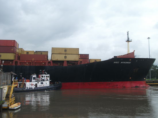 fast geschafft, mit der schnauze ist es schon draussen. 
das kleine boot drueckt mit ganzer kraft dagegen, damit es gerade bleibt.