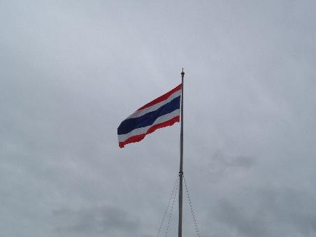 Ein schoenes Wolkenmeer hinter der thailaendischen Flagge.