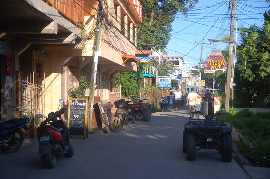 Hauptstrasse in Utila. Fortbewegungsmittel Nr. 1: Roller, Nr. 2: Quadbike, Nr.3: Golfcar... strange...