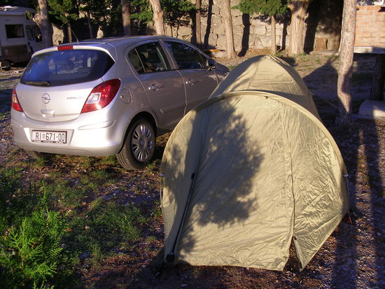 Die Zelt-Lösung auf dem Kiesboden: Festbinden am Auto und an einem Baum.