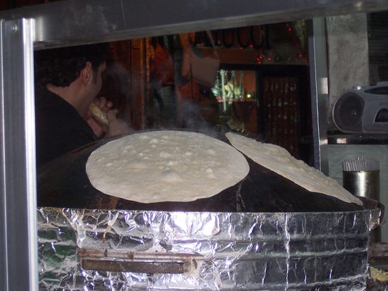 Mit einem Kissen werden die Fladenbrote auf den Kugelofen geworfen, wie eine Pizza belegt und wenn sie fertig sind, gerollt. Köstlich!!