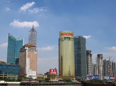 Skyline von Pudong; rechts das Aurora und das Citigroup Gebaeude, im Hintergrund der Jinmao Tower.
Die grosse Luecke in der Bildmitter sind diverse Abrissplaetze, die auf ihre Bebauung warten.