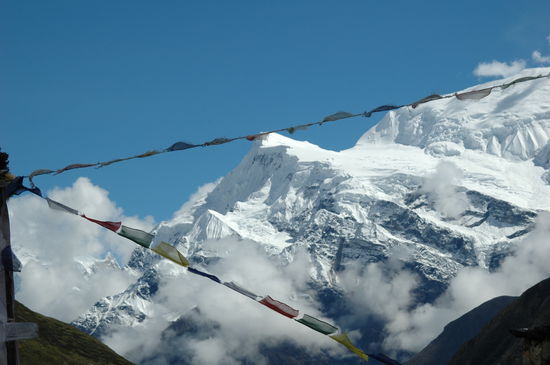 und sieht wunderschöne Berge mit Gebetsfahnen