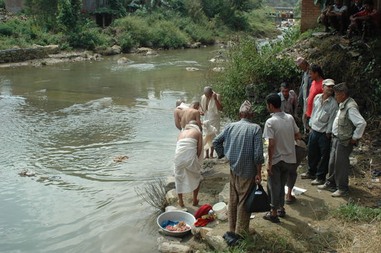 Die Truergäste entledigen sich ihrer Kleidung, die in den Fluss geworfen wird