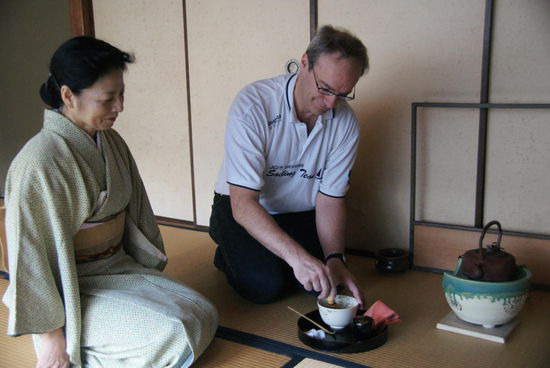 Bei der Teezeremonie: Ich versuche mein Glück am Bambusbesen.