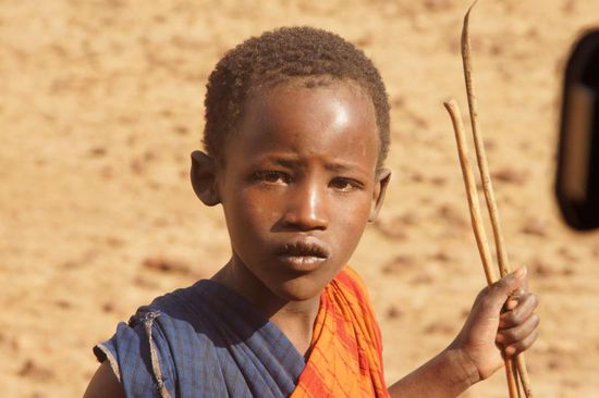 Sichtlich überrascht: Massai-Junge, der Schafe hütet.