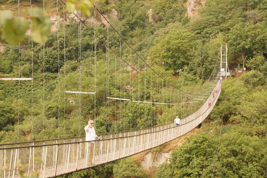 Per Hängebrücke (schmal, wacklig, hoch über dem Talgrund) geht es zum Höhlendorf.
