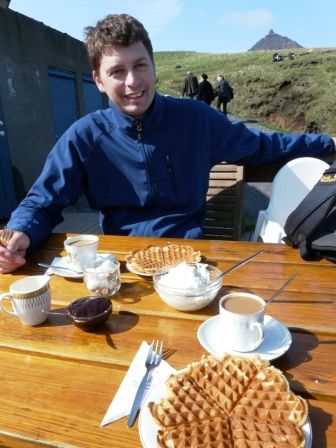 In Hellnar gönnen wir uns Kaffee und Waffeln, auf einer einfachen aber herzlichen Sonnenterrasse mit Blick aufs Meer, die Küstenfelsen und die Vögel