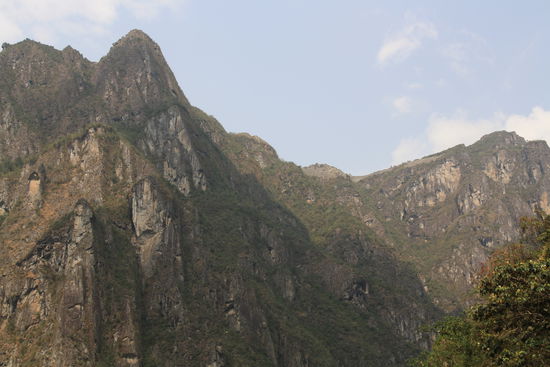 Machu Picchu von unten, immer mal wieder eine Schar von gruenen Papageien, dichter Wald und der reissende Rio Urubamba - Durchaus lohnenswert der Fussweg nach Aguas C.
