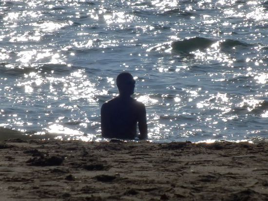 der Schattenmann beim Baden im Flachwasser 