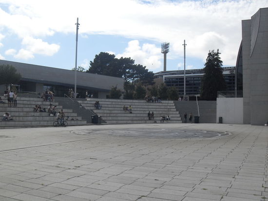 Im Hintergrund sieht man die Glasfassade des Stadions.