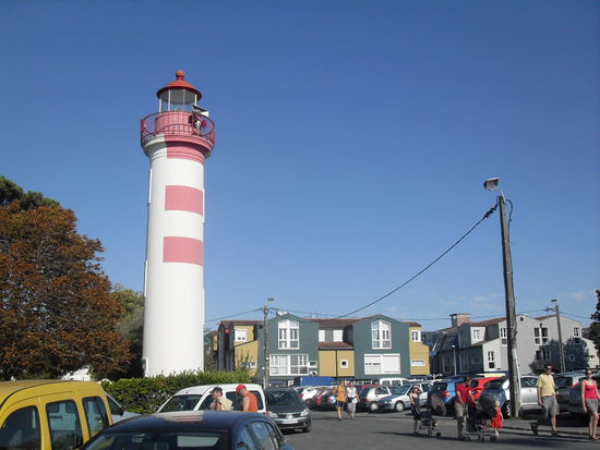 Ein kleiner Leuchtturm sowie im Hintergrund alte, die Stadt charakterisierende Häuser