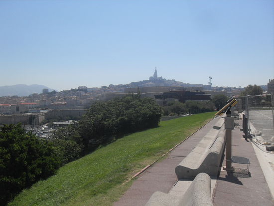 Im Hintergrund erheben sich schon die Berge, auf dem Hügel sieht man die Notre Dame de la Garde.