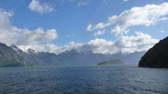 Puerto Montt - ...endlich, der blaue Himmel ist da. So üppig grün sind die Berge in den Fjorden. Eine einmalig schöne Landschaft  auch mit den schneebedeckten Gipfeln im Hintergrund. Doch nur zu sehen, bei gutem Wetter, sonst bleibt diese Schönheit im Nebelgrau verborgen.