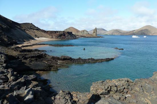 Eine der schoensten Inseln des Archipels: Isla Bartolome, am zackigen Felsten erkennbar. Im Vordergrund ist ein uralter Kratersee.
