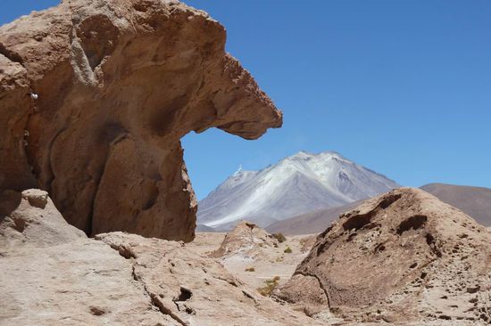 Salar de Uyuni - Nun sind wir in der "normalen" Wueste mit vielen vielen Vulkanen um uns herum. Im Hintergrund ein Vulkan, aber nicht mit Schnee bedeckt, sondern das weisse ist reines Salpeter