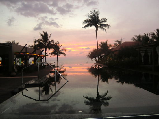 Blick vom Pool auf das Meer bei Sonnenuntergang