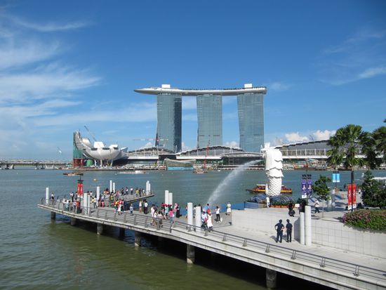 Vorne rechts der wasserspeiende Merlion von hinten und im Hintergrund die drei Hochhäuser des Marina Bay Sands Casino. Drei mit einer Dachterrasse verbundene Hochhäuser. Irgendwie hat es Ähnlichkeit mit einem Bügelbrett! 