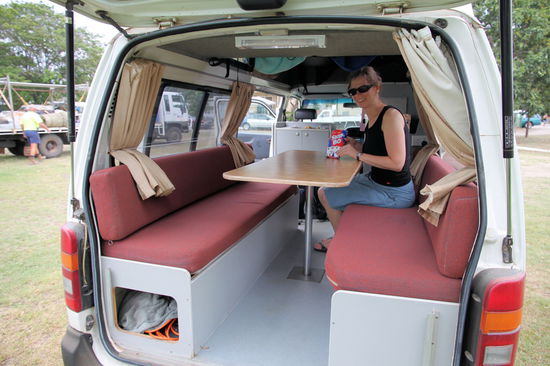 Blick durch die geöffnete Heckklappe auf die 'Tagvariante' mit Sitzbänken und Tisch und Lizzy und Skip Bo Karten!