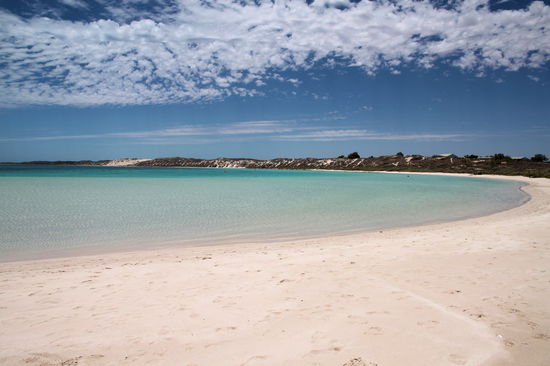 Die andere Hälfte der Bucht von Coral Bay. Hier tummeln sich tagsüber die meisten Touristen und die Bucht eignet sich gut für kleine Kinder zum Schwimmen. Das Bild habe ich mittags aufgenommen. Auch wenn es menschenleer wirkt, waren viele Leute am Strand, aber alle lagen irgendwo am Rand im Schatten der Bäume und Büsche bzw. unter den paar Unterständen die Schatten spendeten. In der Sonne rumzulaufen fühlte sich bei den heißen Temperaturen und dem hellen Sand an, wie unter einem Brennglas. Während ich die Fotos machte blieb Lizzy natürlich im Schatten!
