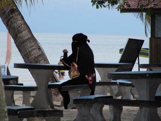 Malaysia zeichnet sich durch seine große Toleranz gegenüber den unterschiedlichen Volksgruppen und ihrer Glaubensrichtungen aus. Die chinesischen Malayen kleiden sich sehr westlich, die muslimischen Malayen teilweise sehr konservativ (s. Bild) und die indischen Malayen bewegen sich dazwischen. Am Strand sieht man daher alles vom knappen Bikini bis zur vollen Verschleierung - nur 'oben ohne' ist für alle strikt verboten.