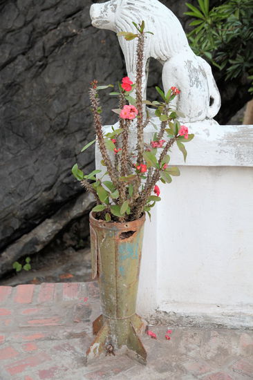 Da es noch ungefähr eine halbe Stunde bis Sonnenuntergang war, gingen wir auf der anderen Seite des Bergs herunter bis zu einer Tempelanlage mit vielen Buddhas und anderen tollen Dingen wie diesem Blumenständer aus ehemaligem Kriegsmaterial.