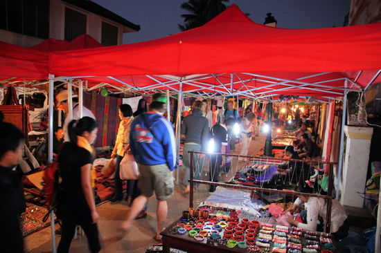Luang Prabang ist eigentlich sehr untypisch für Südostasien. Man kommt sich eher vor wie in einem Freizeitpark. Alles ist recht gut organisiert, aufgeräumt und sauber. Sogar die Pavillons der Marktstände sind alle einheitlich, wenn auch etwas zu niedrig für Europäer über 1,70 Meter. Das Warenangebot auf dem Markt ist dagegen wieder sehr typisch - hier gibt es zu 95% den gleichen Kram wie auf ähnlichen Märkten in anderen Städten Südostasiens.
P.S.: Alle Stände sind ganz brav mit Energiesparlampen beleuchtet!