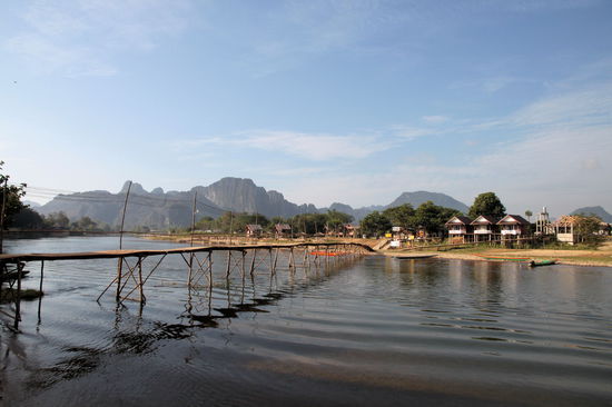 Eine der Fußgängerbrücken auf die Partyinsel "Nam Xong Island". Im Hintergrund die grandiose Berglandschaft.