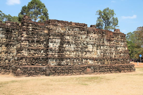 Eine Doppelmauer an einer Seite der Elefantenterrasse. Sowohl die dahinter liegende Mauer als auch die Rückseite der Außenmauer sind ähnlich aufwändig verziert.