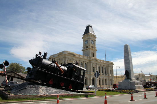 Im Hintergrund das Waitaki District Council Building. Im Vordergrund eine alte Lok und ein Denkmal.